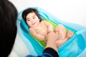 fisher price product photography of asian baby in blue bathtub photographed by boston kids advertising photographer nicole loeb