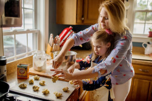 girl making chocolate chip cookies with family in kitchen photographed by boston photographer nicole loeb
