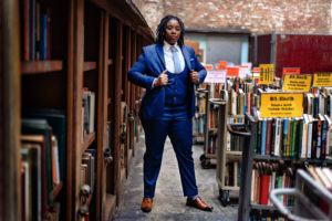 9 Tailors client Sa-kiera female in blue three piece business suit at brattle street book store photographed by boston photographer nicole loeb